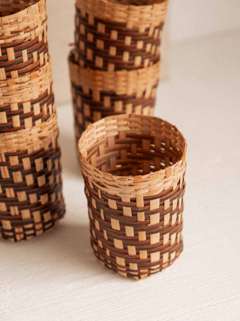 ensemble composé d'une bouteille de verre recouverte de rotin tressé et de 6 cache verre en rotin tressé.