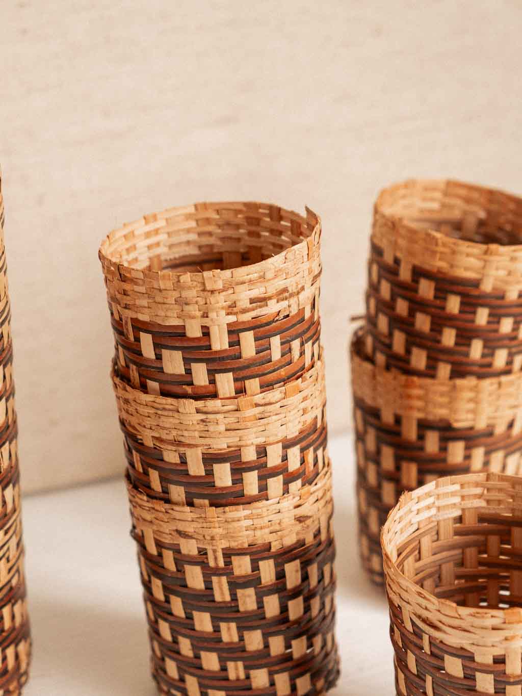 ensemble composé d'une bouteille de verre recouverte de rotin tressé et de 6 cache verre en rotin tressé.