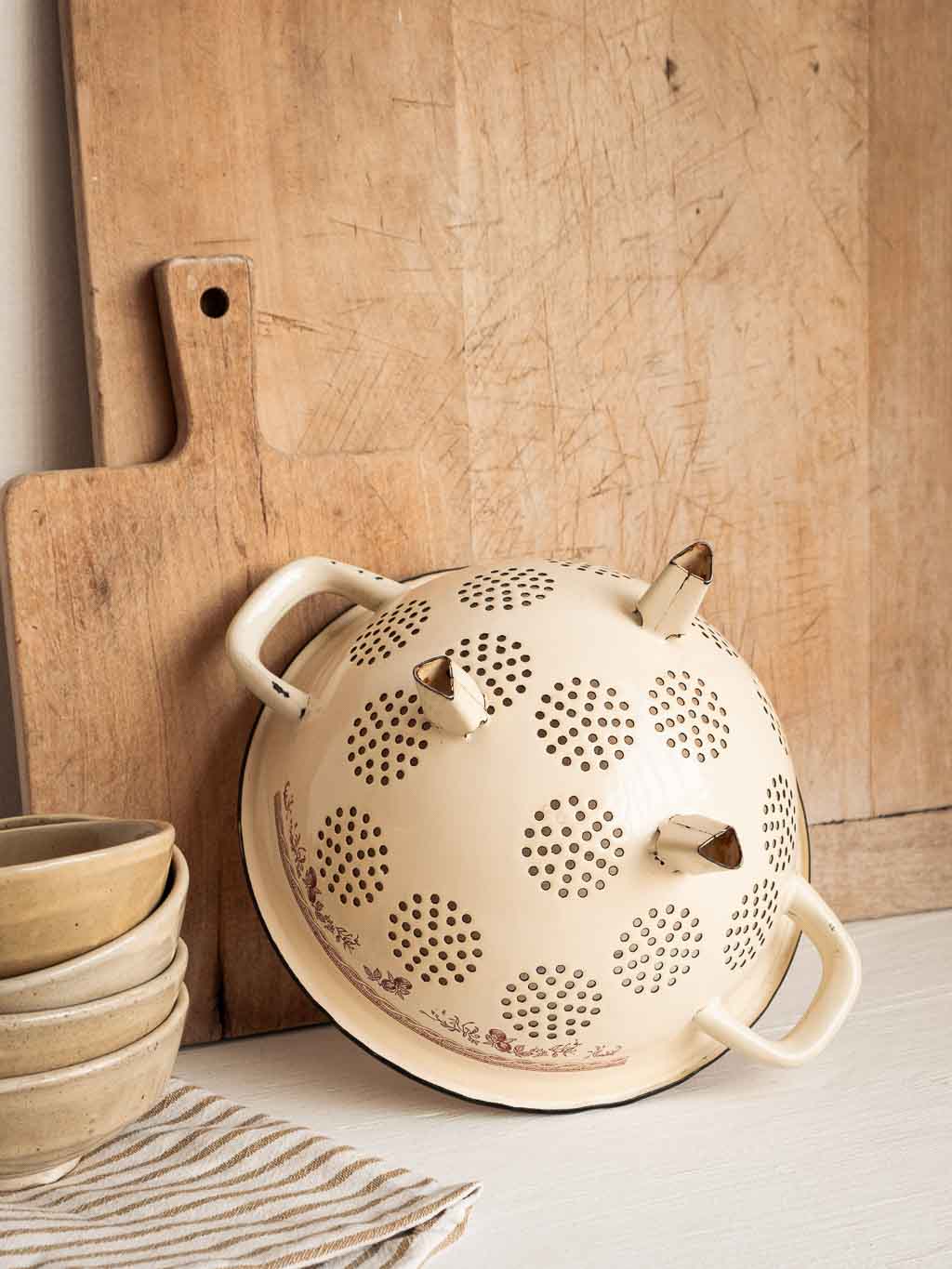 Passoire vintage en métal émaillé beige et motifs rouge, dessous