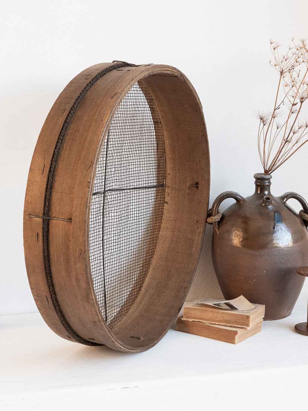 ancien tamis rond en bois utilisé en étagère murale