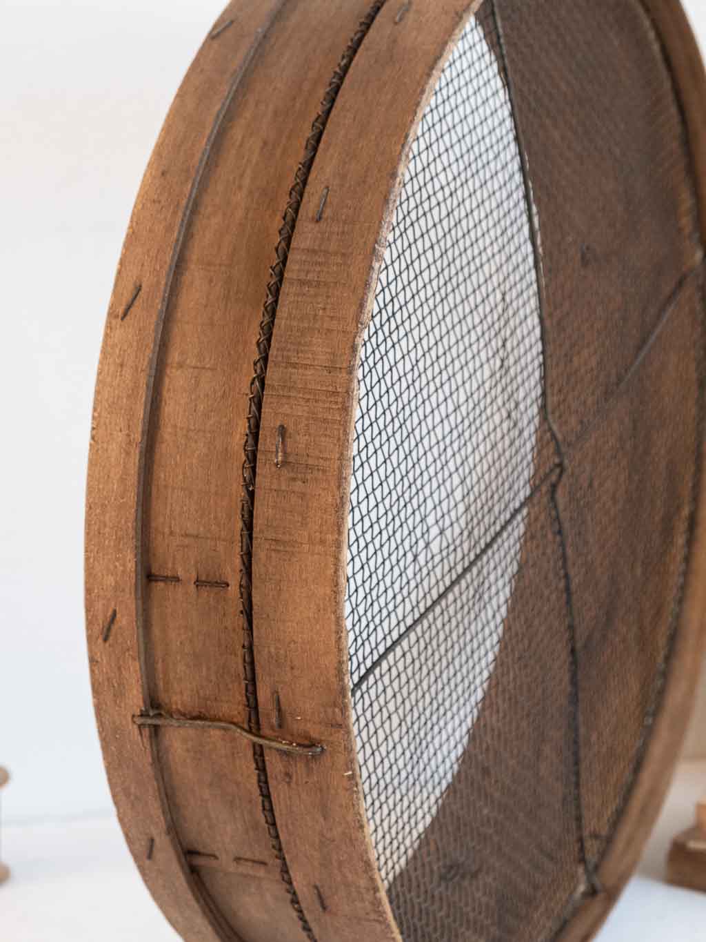 ancien tamis rond en bois utilisé en étagère murale