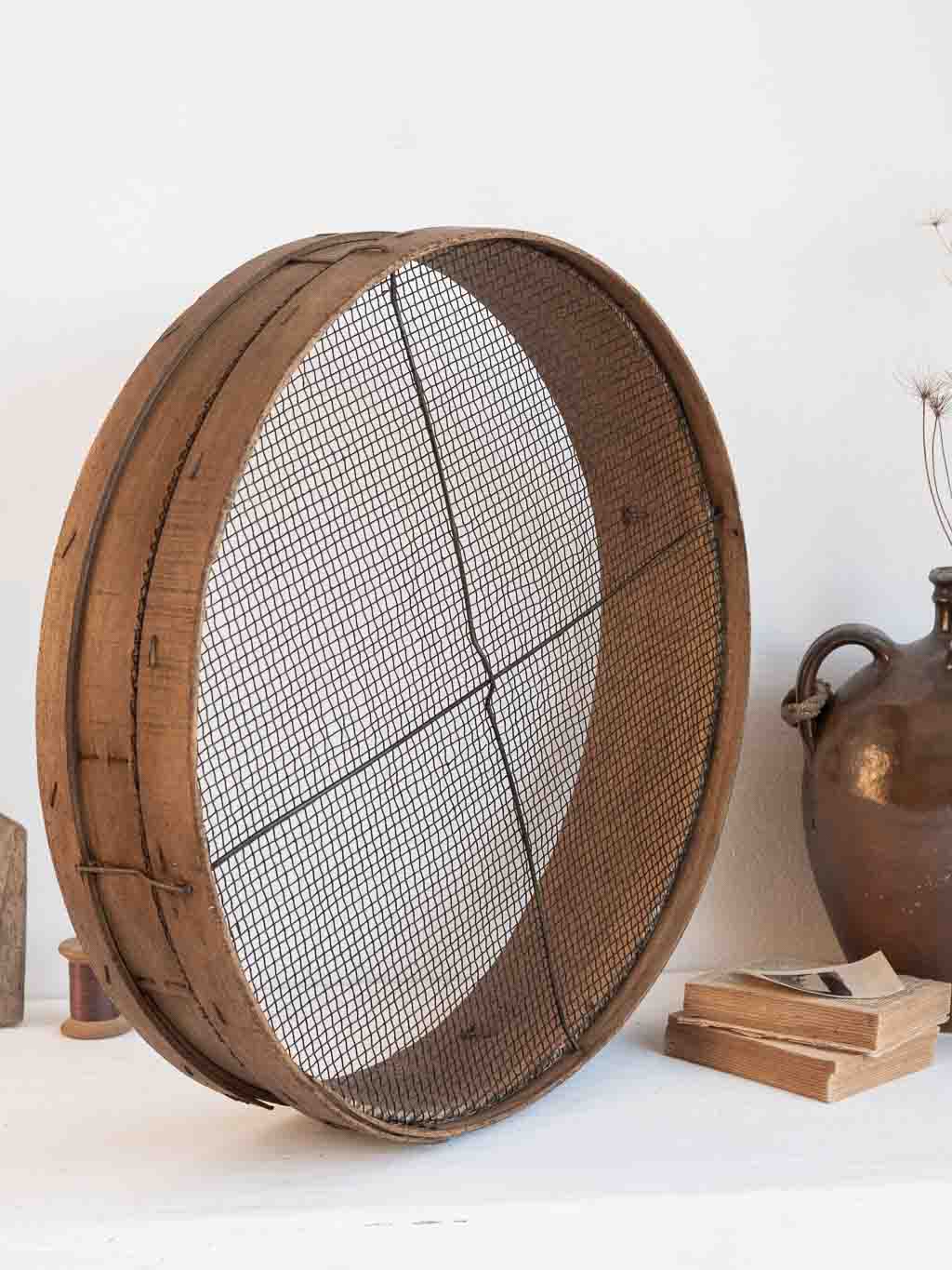 ancien tamis rond en bois utilisé en étagère murale