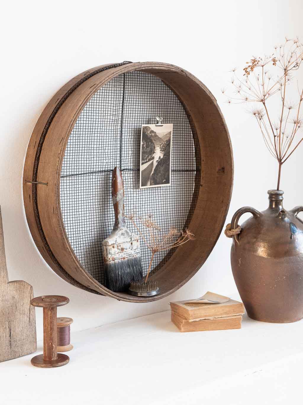 ancien tamis rond en bois utilisé en étagère murale