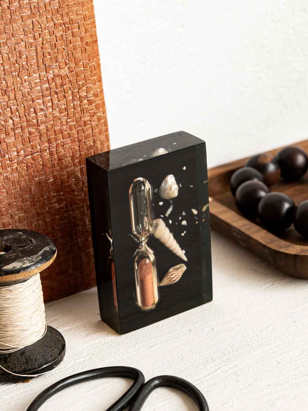 Description : Joli presse papier en résine avec inclusions : sablier et petits coquillages. Un objet déco original qui apporte tout de suite une petite touche bord de mer. Les coquillages pris dans la résine lui donnent un côté léger et délicatement rétro. À poser sur une étagère, un bureau ou une table basse, il trouve facilement sa place dans une déco naturelle, vintage ou esprit vacances. À la fois décoratif et ludique, c’est le genre de petit objet qu’on remarque tout de suite. Une pièce pleine de charme, simple et facile à intégrer dans votre intérieur. Caractéristiques : Matériau : Résine et coquillages Dimensions : 8.5 x 5.2 x 2 cm État : Petites traces d'usage Dans le même univers : → Découvrez notre sélection d’accessoires de bureau vintage ici.
